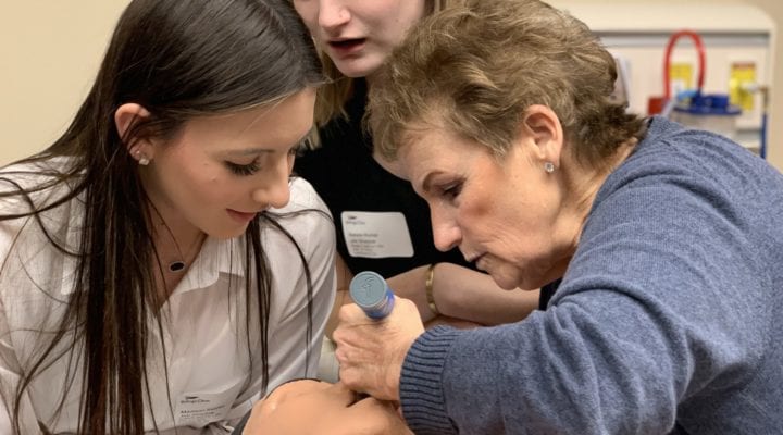 Montana HOSA students being shown how to intubate on a manikin by a hospital partner